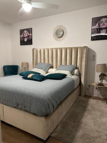 une chambre avec un grand lit avec une grande tête de lit dans l'établissement T2 proche stade de Frace Paris très calme design & Parking privé, à Bobigny