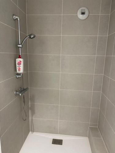 a bathroom with a shower with a shower head at T2 proche stade de Frace Paris très calme design in Bobigny