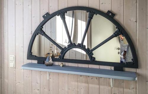 ein Spiegel hängt an einer Wand mit einem Regal in der Unterkunft Friedrichskoog-deichblick 4 in Friedrichskoog