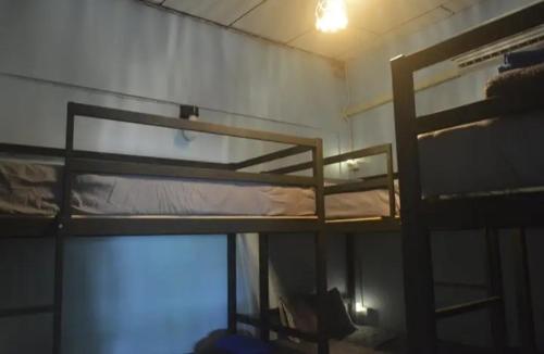 a room with two bunk beds and a tv at The Lion House in Khlaung Phai Bae