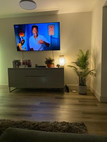 a living room with a flat screen tv on a wall at Princes Risborough, Buckinghamshire, comfortable double room, quiet and central location in Buckinghamshire