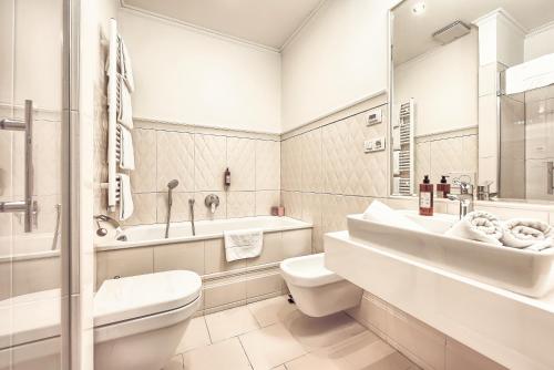 a white bathroom with a sink and a toilet at Milosrdnych Apartments in Prague