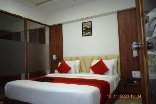 a hotel room with two beds with red pillows at LEELA BIZOTEL in Junagadh