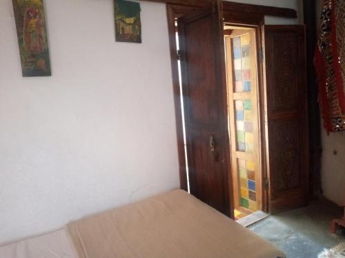 a bedroom with a bed and an open door at Dar KamalChaoui in Bhalil