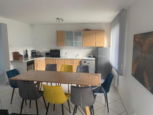 une cuisine avec une table et des chaises en bois dans l'établissement Maison Bord de Mer, à Dieppe