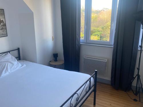 um quarto com uma cama e uma janela em Maison Bord de Mer em Dieppe