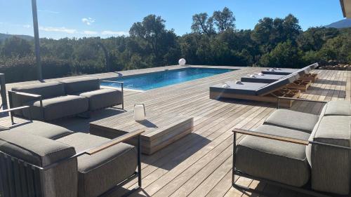 une terrasse avec des chaises et une piscine dans une maison dans l'établissement Villa A Licciola, à Porto-Vecchio