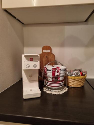a counter with a coffee maker and cups on it at POČITNIŠKA HIŠA SONČNI VRH in Spodnji Ivanjci