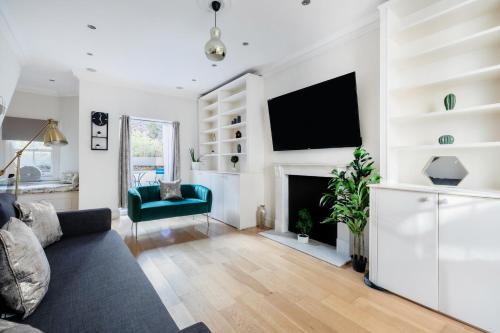 a living room with a couch and a fireplace at Beautiful 4 Bedroom House near Paddington Station in London