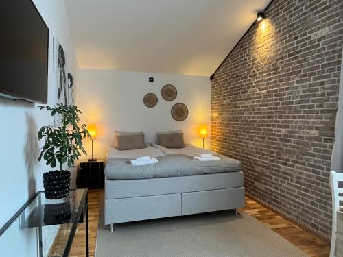 a bedroom with a bed and a brick wall at Spirit Bed & Breakfast in Ekeby