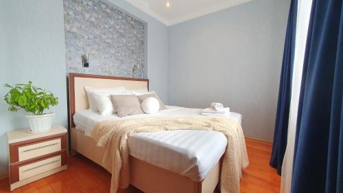 a bedroom with a bed with a plant on it at Возле Байтерека для 1-4 человек с кроватью и раскладным диваном in Astana