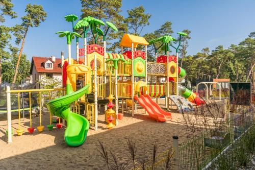 um parque infantil com escorrega na areia em Bursztynowo em Kąty Rybackie