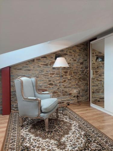 a living room with a chair and a brick wall at SAN FRANCISCO in Ribadeo