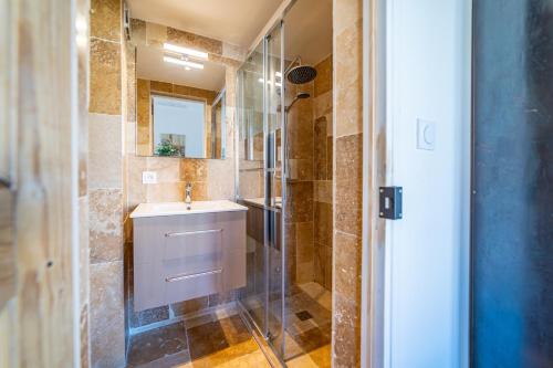 une salle de bain avec un lavabo et une douche en verre dans l'établissement La Cathédrale de Bois, à Nîmes