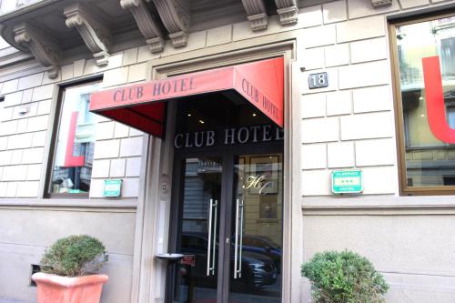 un negozio di fronte a una club house con un tendone rosso di Club Hotel a Milano