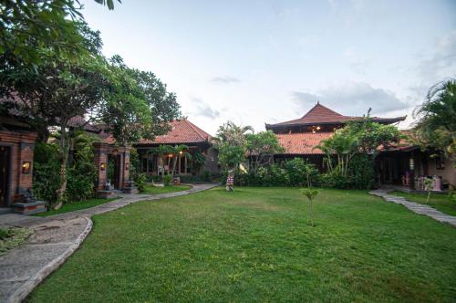 a yard of a house with a grass yard at Kubuku Eco Dive Lodge and Yoga in Pemuteran
