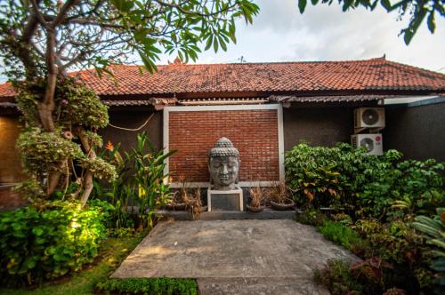 a statue of a head in front of a house at Kubuku Eco Dive Lodge and Yoga in Pemuteran