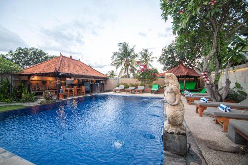 a swimming pool with a statue next to a resort at Kubuku Eco Dive Lodge and Yoga in Pemuteran