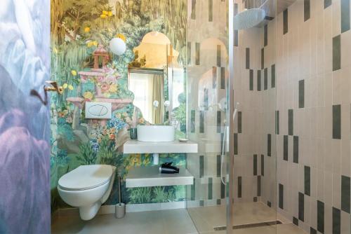 ein Bad mit einem WC und einem Blumenbild in der Unterkunft Little Heaven Apartments in Sibiu