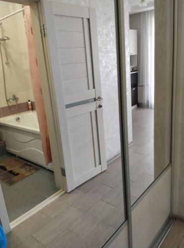 y baño con puerta y bañera. en VIP apart 284, en Tiflis
