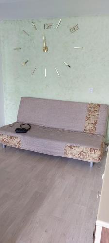 een bed in een kamer met een klok aan de muur bij VIP apart 284 in Tbilisi City