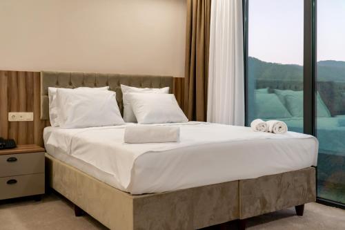 a bedroom with a large bed with towels on it at Chateau Milisi in Batumi
