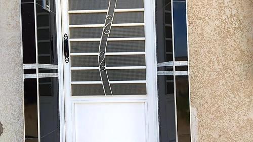 białe drzwi z oknem na budynku w obiekcie Alliance mehdia w mieście Kenitra