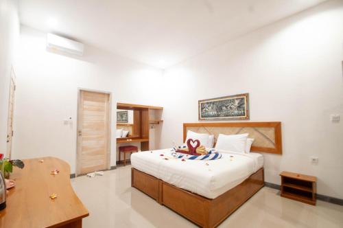 a bedroom with a bed and a desk in it at Kubuku Eco Dive Lodge and Yoga in Pemuteran