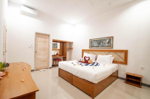 a bedroom with a bed and a desk in it at Kubuku Eco Dive Lodge and Yoga in Pemuteran
