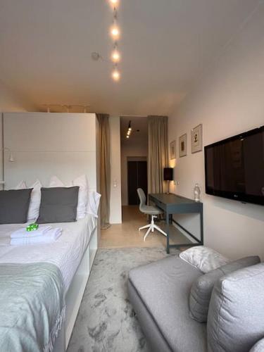 een slaapkamer met een bed, een bureau en een televisie bij Quiet and sunny studio in Ddorf absolut city center in Düsseldorf