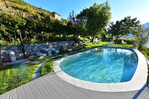una piscina en un patio con terraza de madera en RUSTICO VIGNA casa vacanze en Civo