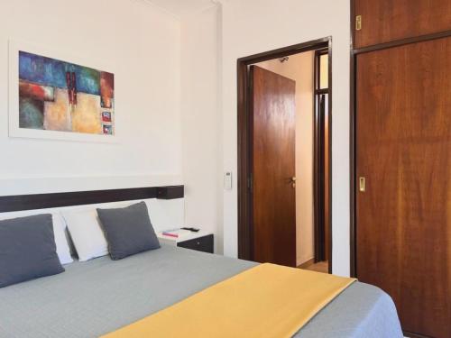 um quarto com uma cama e uma porta de madeira em Depto Las Heras em Villa Carlos Paz