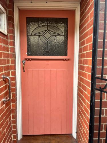 サンドリンガムにあるSeaside cottageの赤いガレージドア(窓付)