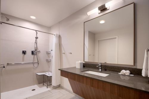 a bathroom with a sink and a shower and a mirror at Fairfield Inn & Suites by Marriott Cleveland Tiedeman Road in Brooklyn