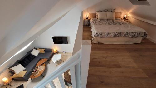 1 dormitorio en el ático con 1 cama y 1 sofá en Gite Urbain - La bulle de champagne - Parking, en Épernay