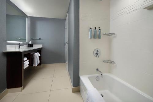 a white bathroom with a tub and a sink at Residence Inn by Marriott Green Bay Downtown in Green Bay