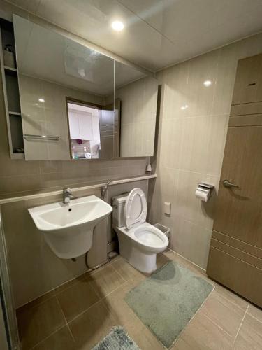 a bathroom with a sink and a toilet and a mirror at Spacious Luxury Condo w/ kitchen beside Hilton Clark D’Heights in Pampang