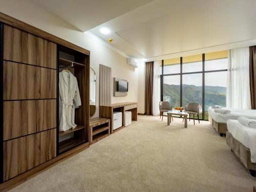 a hotel room with a bed and a tv and a bedroom at Chateau Milisi in Batumi