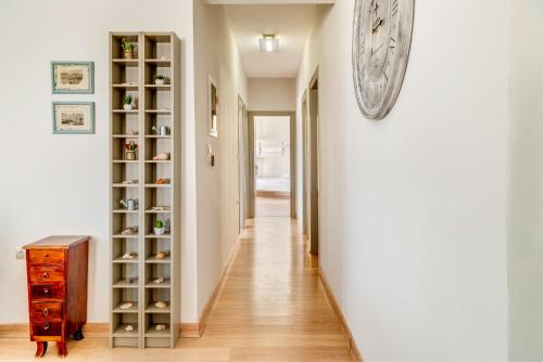a hallway with a clock on the wall and a wooden cabinet at Villa Maria Fabrika Syros in Vari