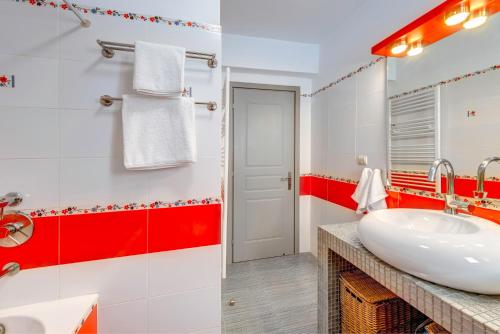 baño con lavabo blanco y detalles en rojo en Villa Maria Fabrika Syros, en Vári