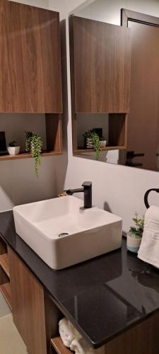 La salle de bains est pourvue d'un lavabo blanc sur un comptoir. dans l'établissement ¡Disfruta de tecnología y glamour!, à Santa Cruz de la Sierra