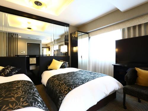 Habitación de hotel con 2 camas y TV de pantalla plana. en APA Hotel Higashi-Nihombashi-Ekimae en Tokio