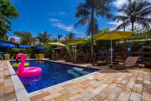 uma piscina com um cisne cor-de-rosa no meio em Pousada Villa Blu Maresias em Maresias