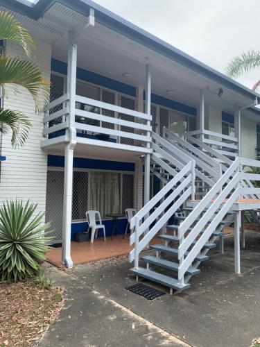a house with white stairs and a porch at The Bay Beach Shack, Hervey Bay in Hervey Bay