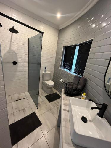 a bathroom with a sink and a shower and a toilet at Wildevy at Benlize in Hartbeespoort
