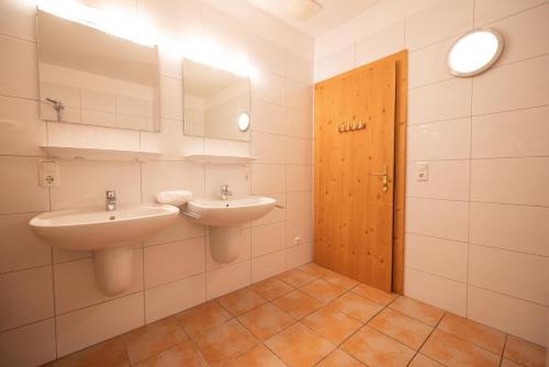 a bathroom with two sinks and a mirror at All Seasons Lodge by All in One Apartments in Kaprun