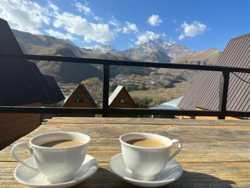 two cups of coffee on a table with a view at Guesthouse Elli & Cottages in Stepantsminda