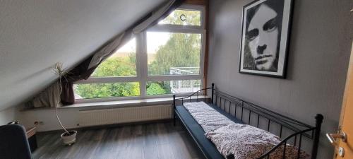 um quarto com uma cama e uma grande janela em Vierzimmerwohnung am Harkortsee em Wetter