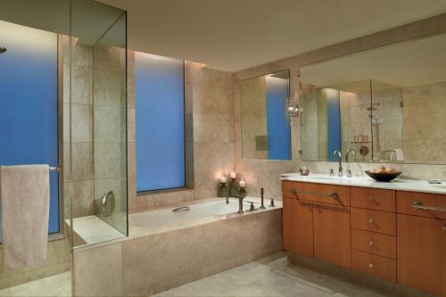 a bathroom with a tub and a shower and a sink at Ritz Carlton DIFC Downtown Dubai in Dubai