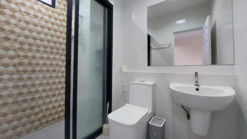 a bathroom with a toilet and a sink and a mirror at Cozy Apartment Chaweng Center in Chaweng